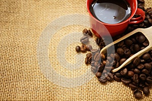 Coffee beans , a scoop and coffee in a red cup