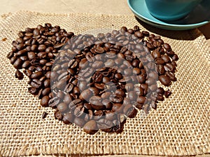Coffee beans in shape of heart on a background of burlap