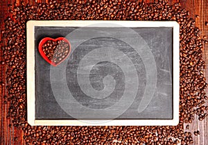 Coffee beans in the shape of heart on a black chalkboard, a lovers flower lovers for Valentine's Day