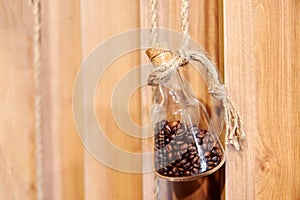 Coffee beans, in a small glass bottle with a cork, suspended on a scourge