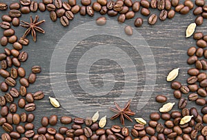 Coffee beans and spices on wooden background