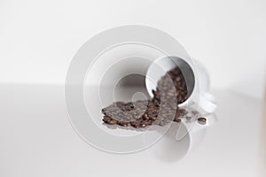 Coffee beans spilling out of white mug isolated symbol breakfast service with textspace