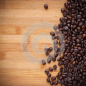 Coffee Beans spilling on to a wooden benchtop photo