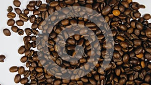 The coffee beans spin rotate quickly fast fly, dispart, splash to the sides with centrifugal coriolis force. Coffee