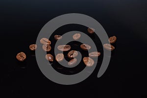 Coffee beans spread on black background
