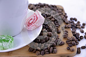 Coffee beans and sweets on a white saucer