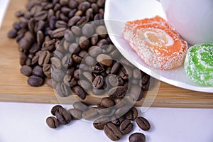 coffee beans and sweets on a white saucer