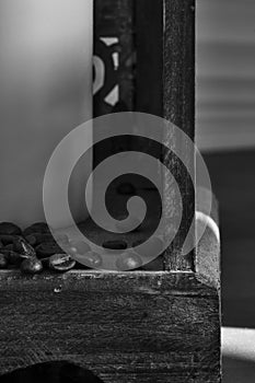 coffee beans trickling out of a wooden lantern, black and white