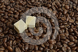 Coffee beans and two pieces of sugar