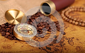 Coffee Beans and Vintage Compass with  magnifying glasson an old world map - trade and explorer concept