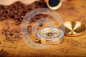 Coffee Beans and Vintage Compass with  magnifying glasson an old world map - trade and explorer concept