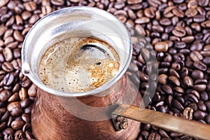 Coffee beans, vintage copper coffee pot closeup, cezve or ibrik photo
