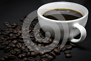 Coffee beans and white ceramic coffee mug