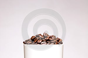 Coffee beans in white cup isolated on gray background