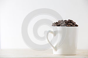 Coffee beans in white cup isolated on white background
