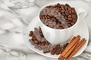coffee beans in a white mug on a saucer