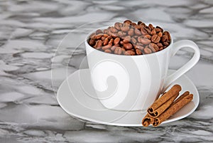 coffee beans in a white mug on a saucer