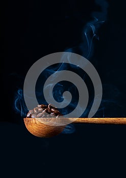 Coffee beans in Wood Spoon Steam rising from Beans