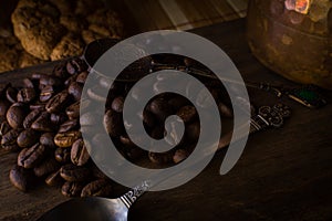 Coffee beans on wood with spoons and cookies photo