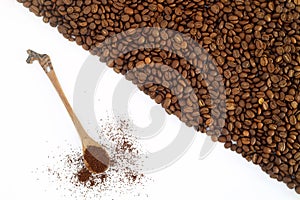 Coffee beans in a wooden scoop isolated on a white background.