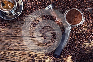 Coffee. Black coffee with coffee beans and portafilter on old oak wooden table photo