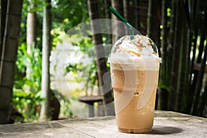 Coffee blend in plastic cup. Served with whipped cream topping and sweet syrup.