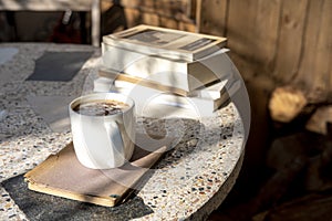 coffee and books on an old table with a background of old rustic woods