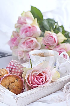 Coffee and bouquet of pink roses in bed, romance and coziness. Good morning. Breakfast in bed. Copy space