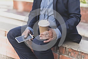 coffee break concept. Successful handsome mature entrepreneur resting with cup of coffee outdoors enjoy sunny spring