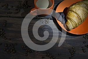 Coffee break. Croissant, chocolate and a Cup on the table.