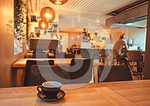 Coffee break with cup on table of restaurant or cafe. Interior bar lonly drinking visitor