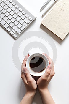 Coffee break, table top view, coffee cup in hands, work desk