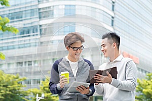 Coffee break. Two cheerful business men talking while one of the