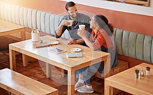 Coffee, cafe and barista couple at table drinking, talking and laughing at funny meme. Small business, owners or happy