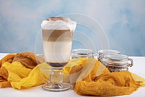 Coffee cafe latte macchiato in a high glass on a wooden background. There is copy space next to the glass photo