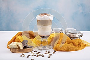 Coffee cafe latte macchiato in a high glass on a wooden background. There is copy space next to the glass photo