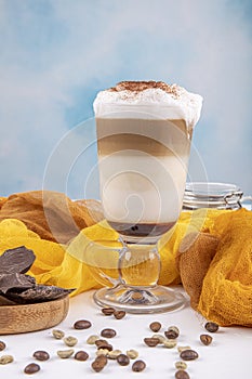 Coffee cafe latte macchiato in a high glass on a wooden background. There is copy space next to the glass photo