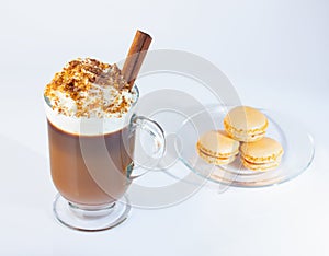 Coffee, cappuccino in a glass, Irish glass. Whipped cream sprinkled with ground nuts and chocolate chips, a cinnamon stick. Glass