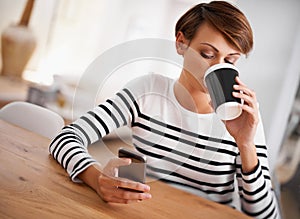 Coffee and a catchup text. a young woman drinking coffee while texting on her phone.