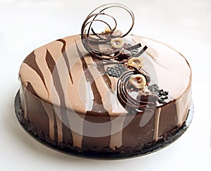 Coffee and chocolate cake with spiral chocolate decoration and hazelnuts