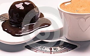 Coffee and chocolate cake on weighing scale