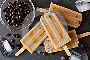 Coffee and chocolate chip ice pops, overhead view on slate