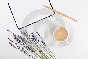 Coffee, clean notebook and lavender flower on white table top view. Woman working desk. Cozy breakfast. Mockup. Flat lay style.