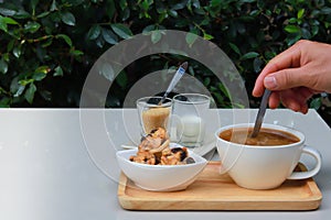 Coffee and cookie on white table in restaurant garden.