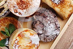 Coffee and cookies on rustic wooden background. Top view, close up, selective focus. Promotional shooting.