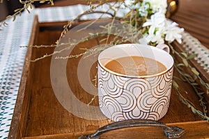 Coffee with Creamer Cup on wooden table with flowers photo