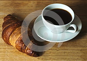 Coffee and croisant on wooden table photo