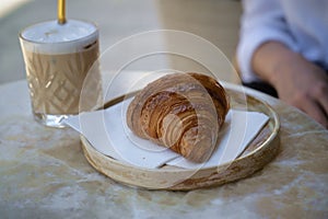 Coffee and croissant on the table at outdoor cafe