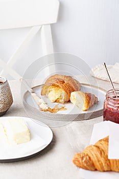 Coffee with croissant. Traditional french breakfast. Bright sunny morning, vertical