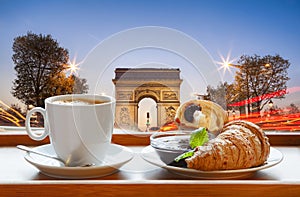 Coffee with croissants against Arc de Triomphe in Paris, France